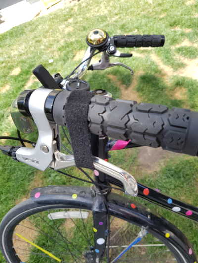 A velcro strap wrapped around the brake lever of a bicycle